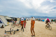 Burning Man burners wearing crazy burning man clothes with giant panda head on Black Rock City playa 